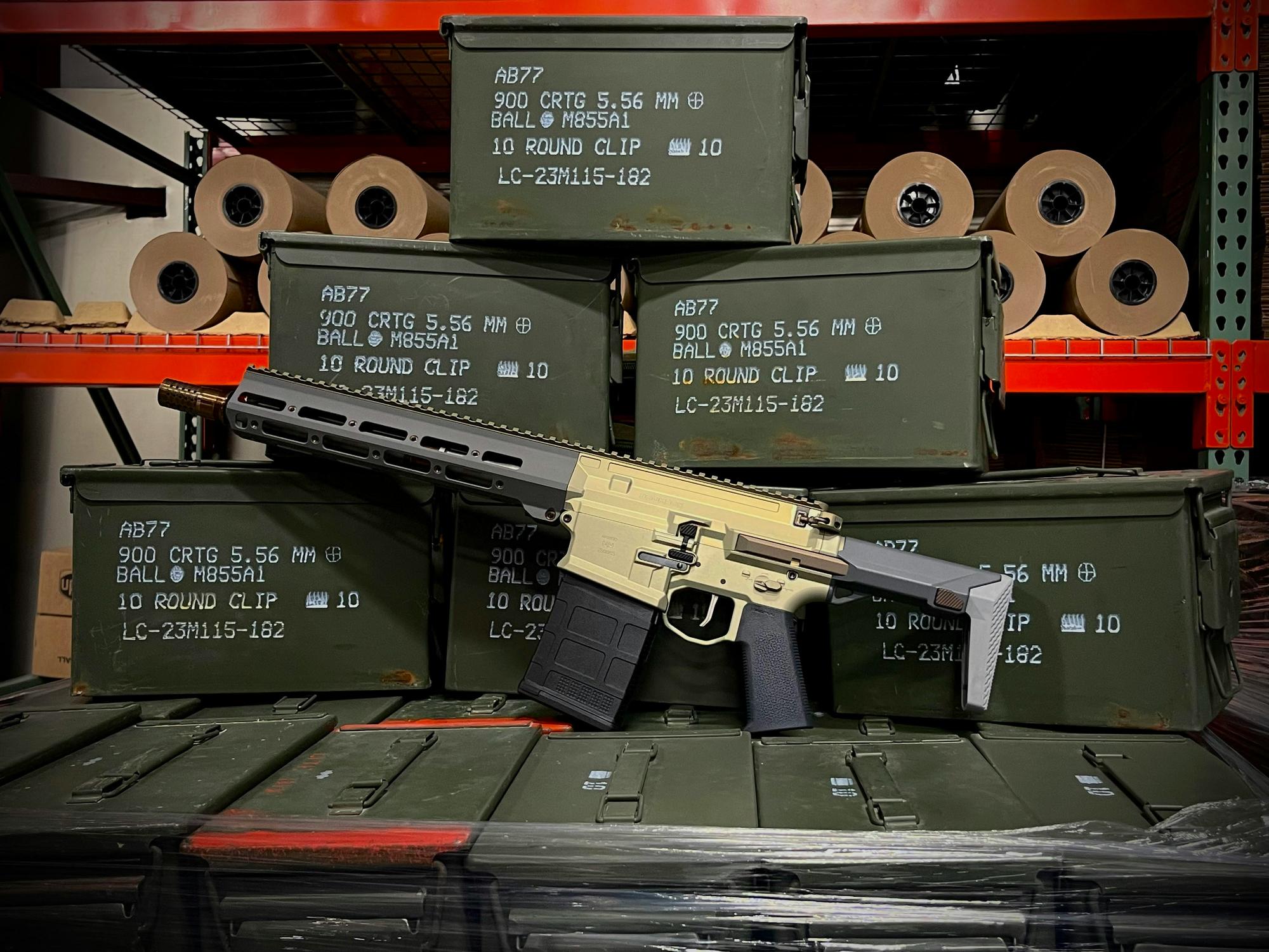 A custom rifle build resting against stacked ammunition crates